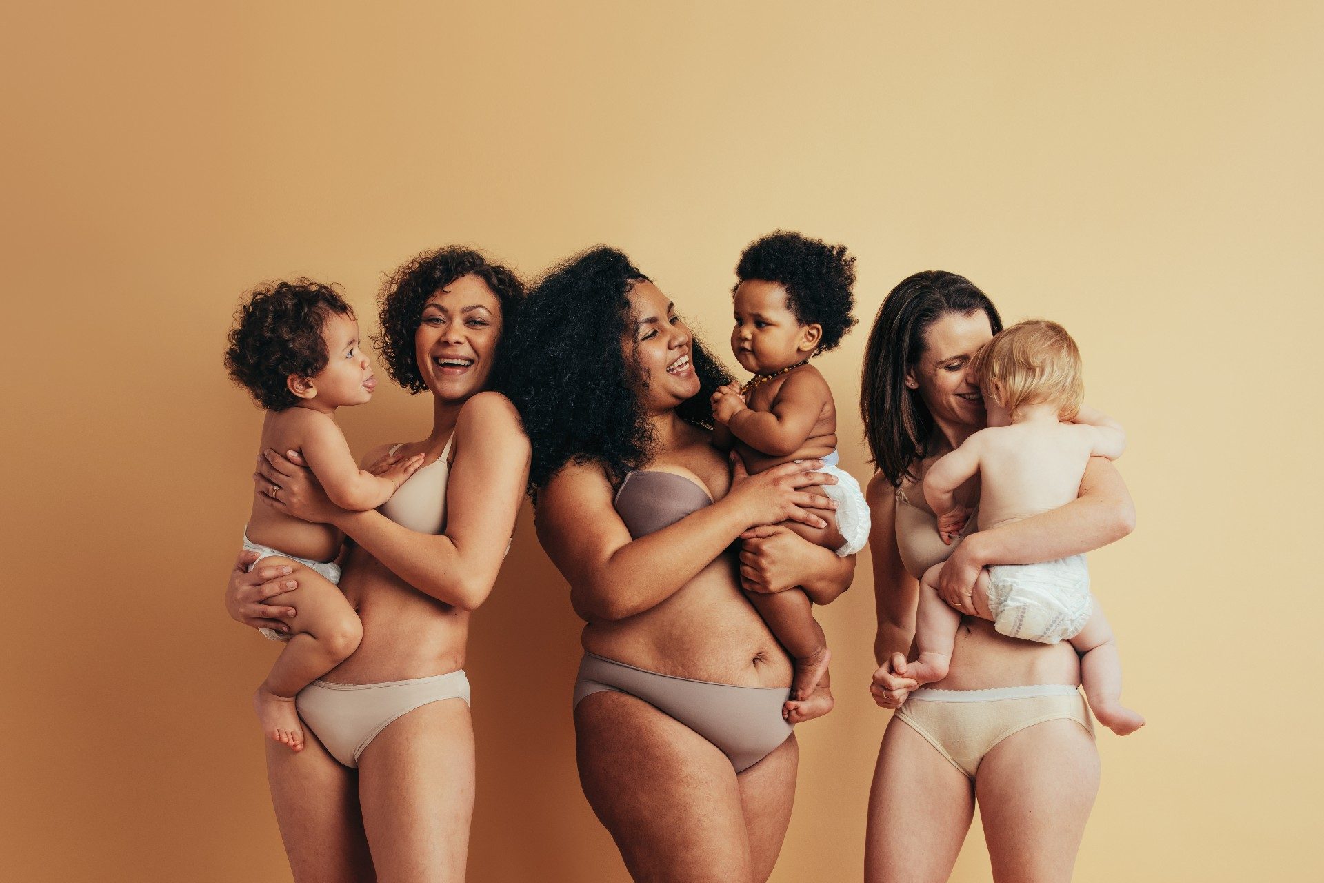 Three women standing together with their babies