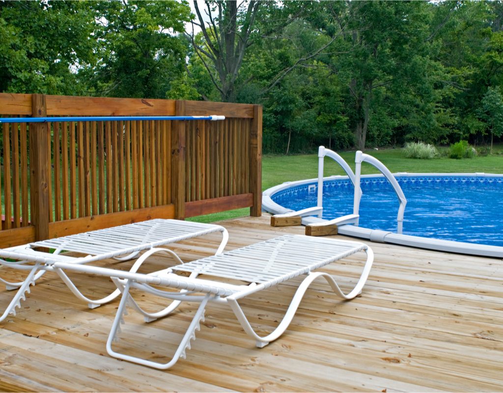 backyard above ground pool with a deck