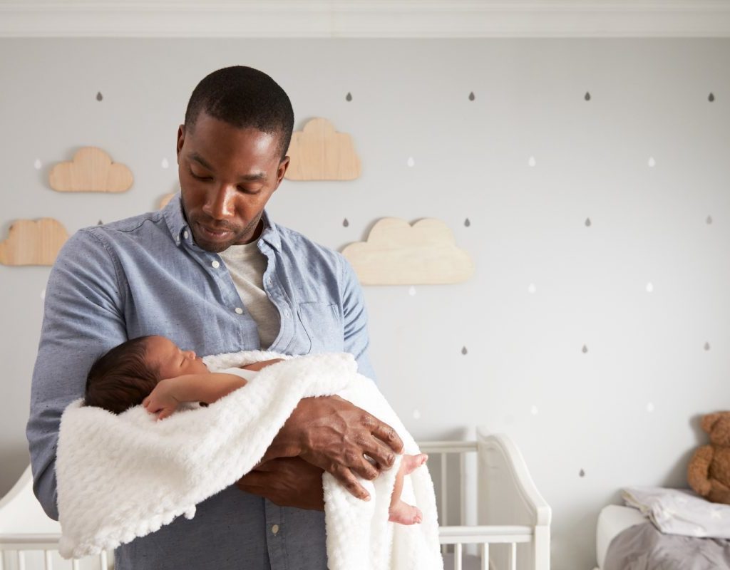 dad holding baby in nursery