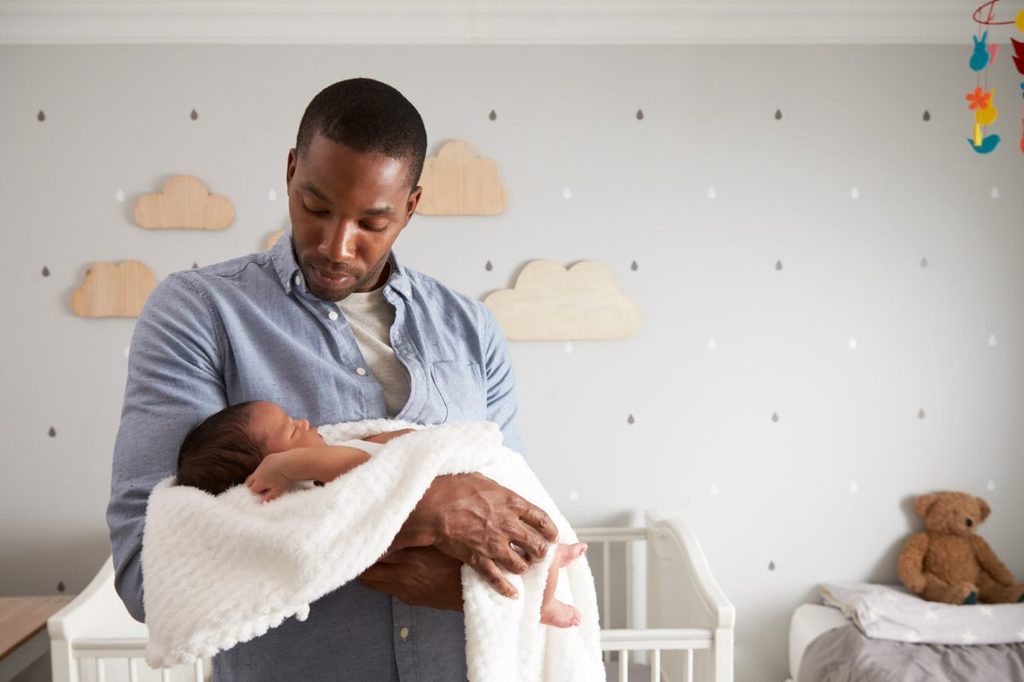 Dad holding baby in the nursery.