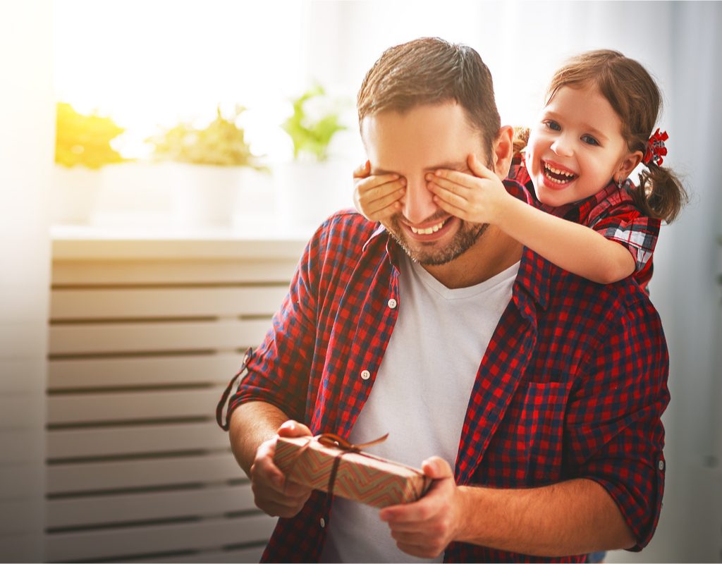 Little girl with dad holding a wrapped gift