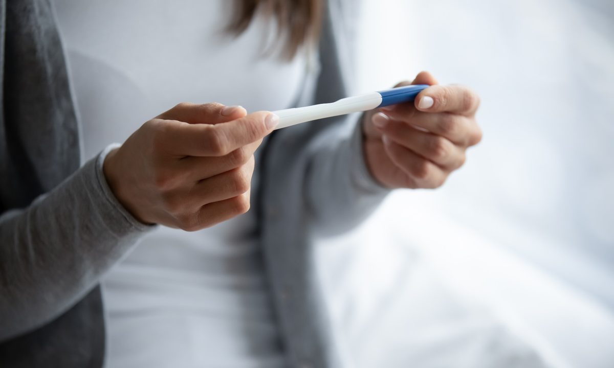 Woman holding a pregnancy test