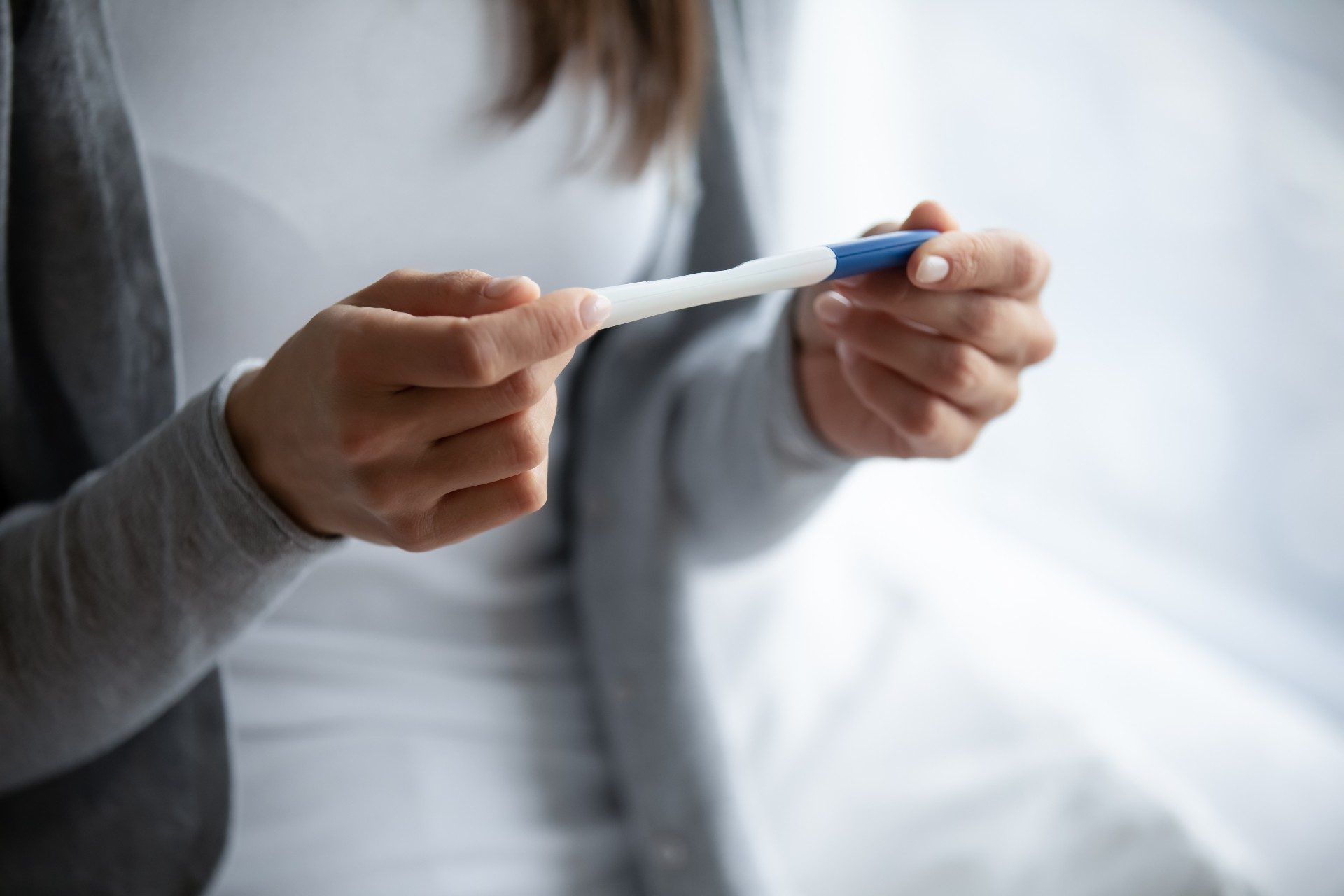 Woman holding a pregnancy test.