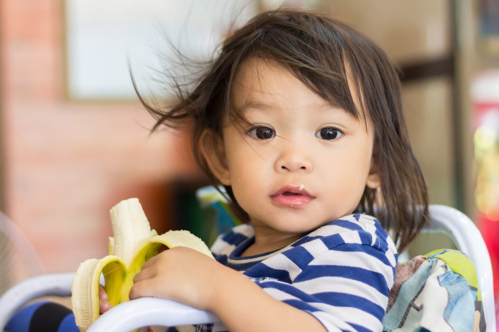 Toddler eating a banana