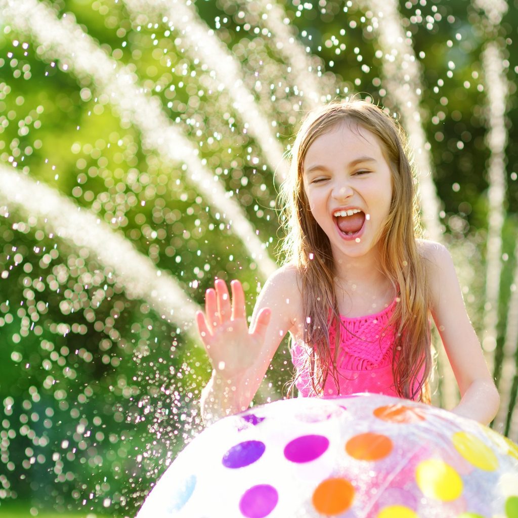Girl laying with a sprinkler