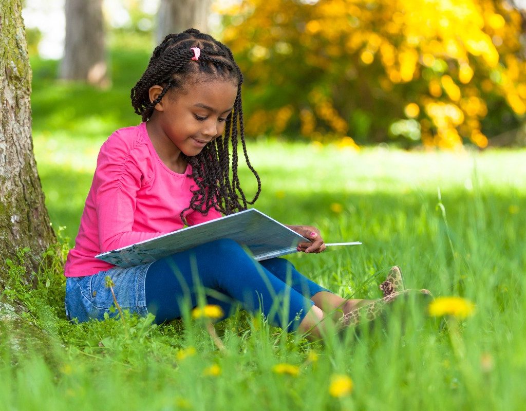 Girl reading under tree