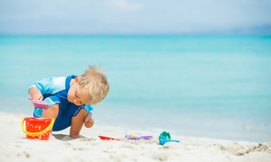 Little boy making a sandcastle at a beach