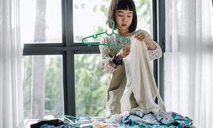 Little girl hanging up sweater