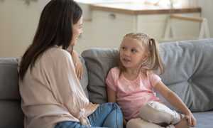 Mom and preschooler talking on a couch