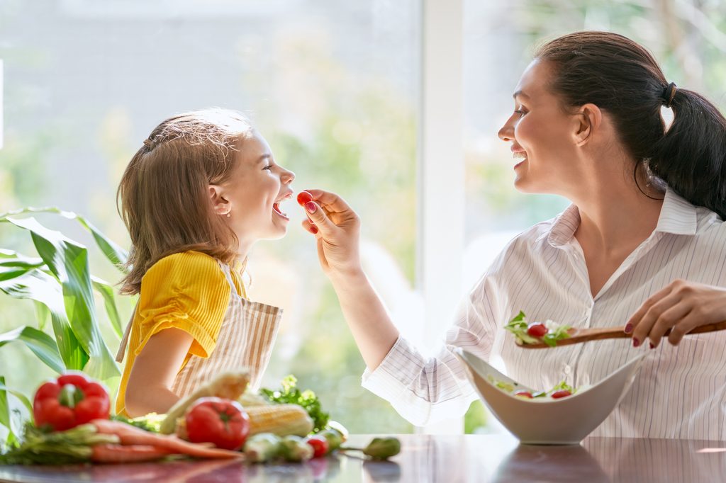Mother and daughter eating vegetables