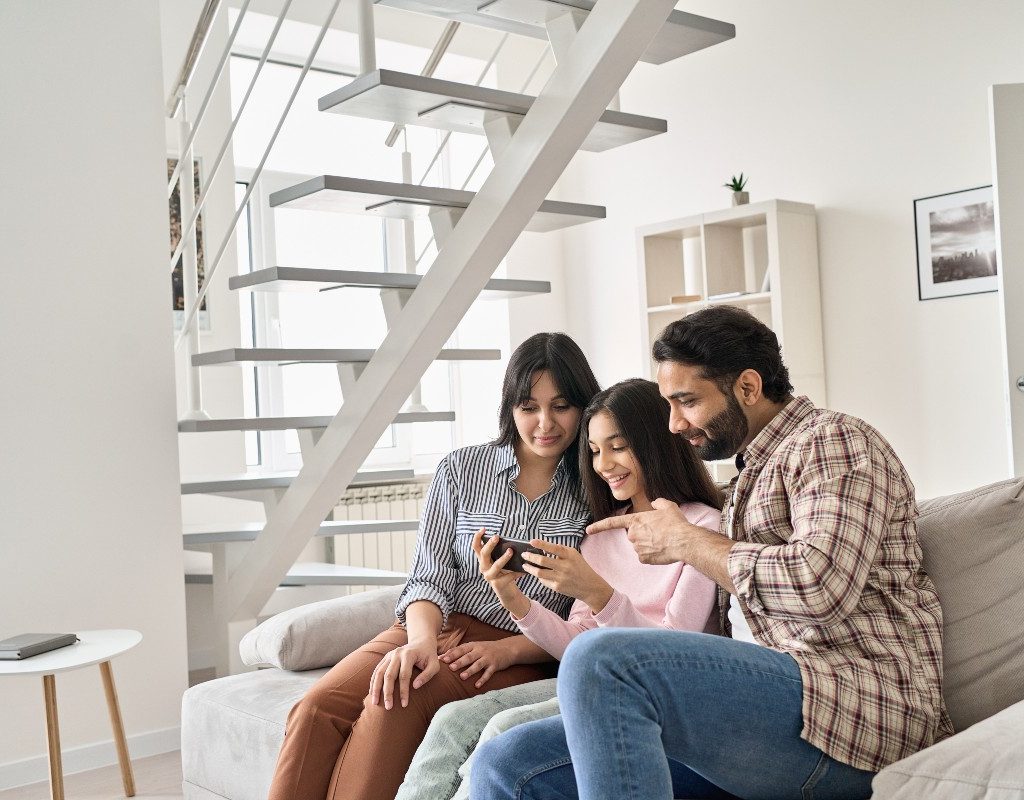 Parents talking to teenage girl while looking at a cell phone