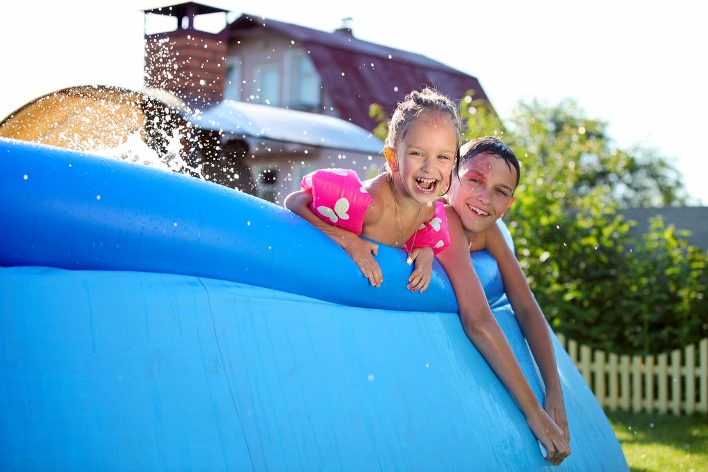 Two siblings in a pool.