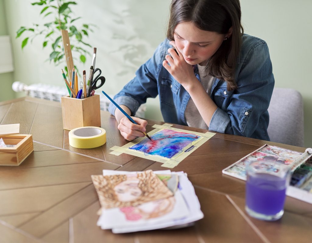 Teen painting at a table