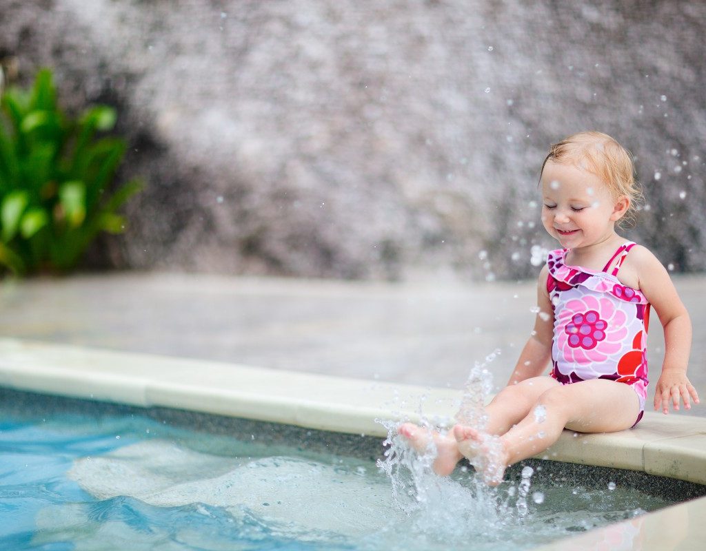 toddler dipping feet in pool