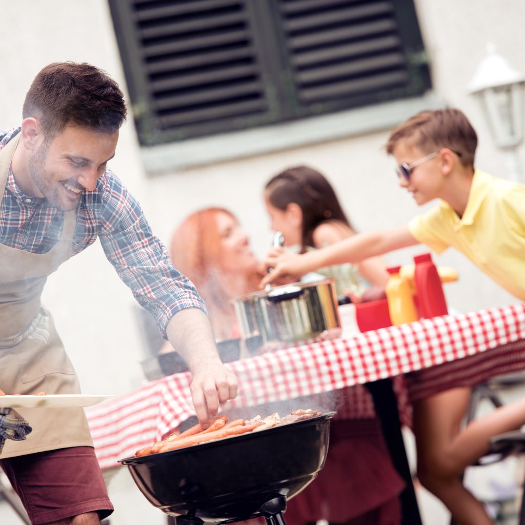 Man cooking with kids in background