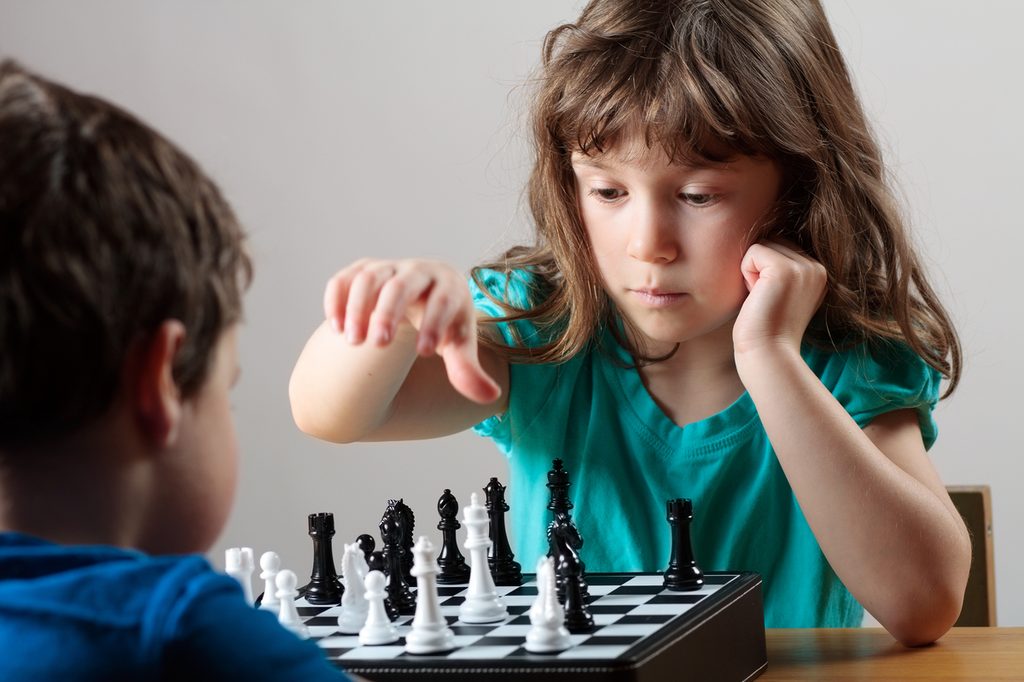 Girl and boy playing a game of chess