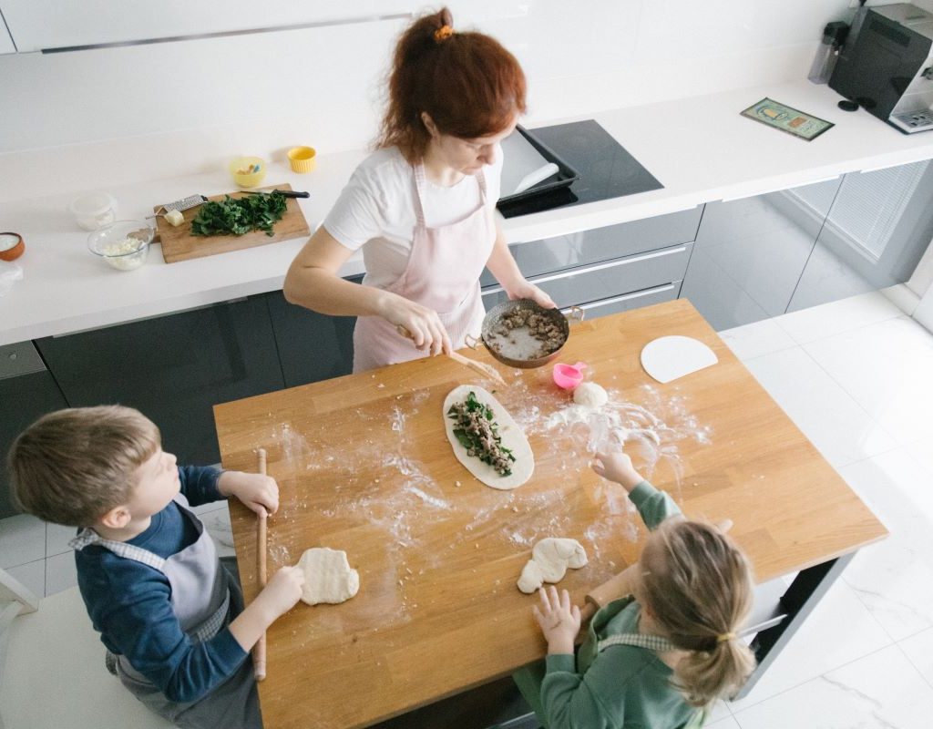 A parent and kids baking together in the kitchen