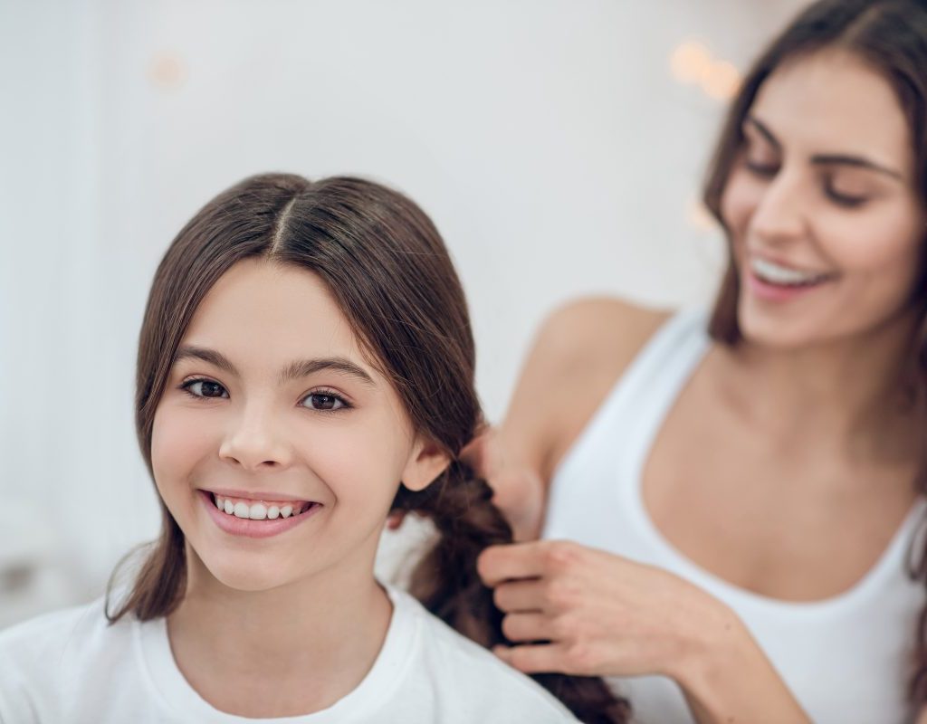 mom fixing daughter's hair