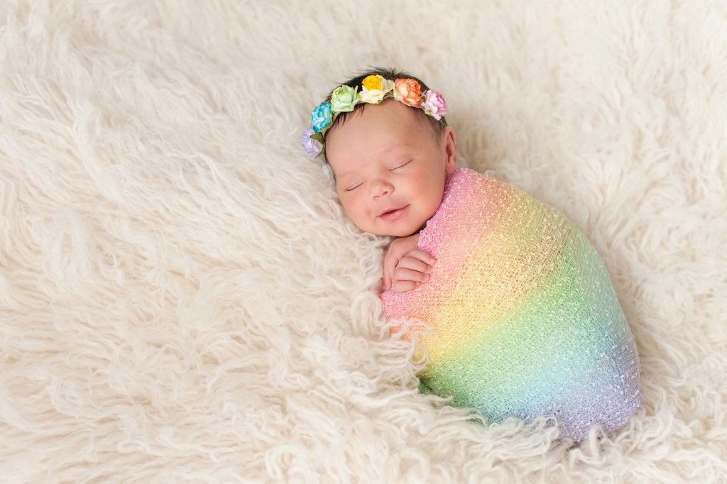 sweet baby girl sleeping in a rainbow blanket