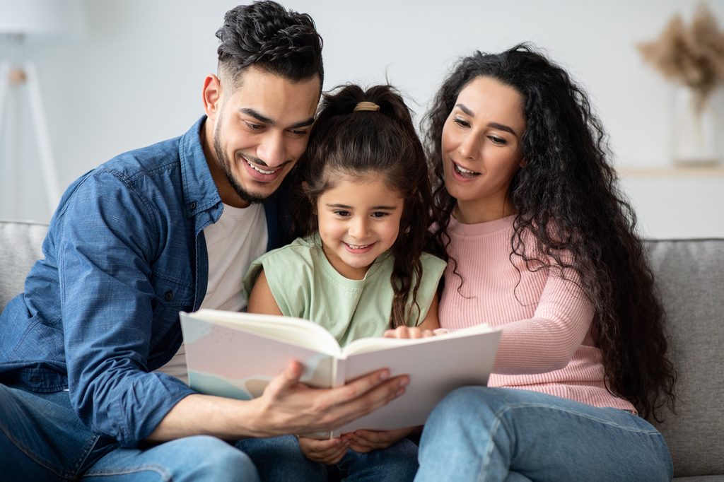 Child reading with parents