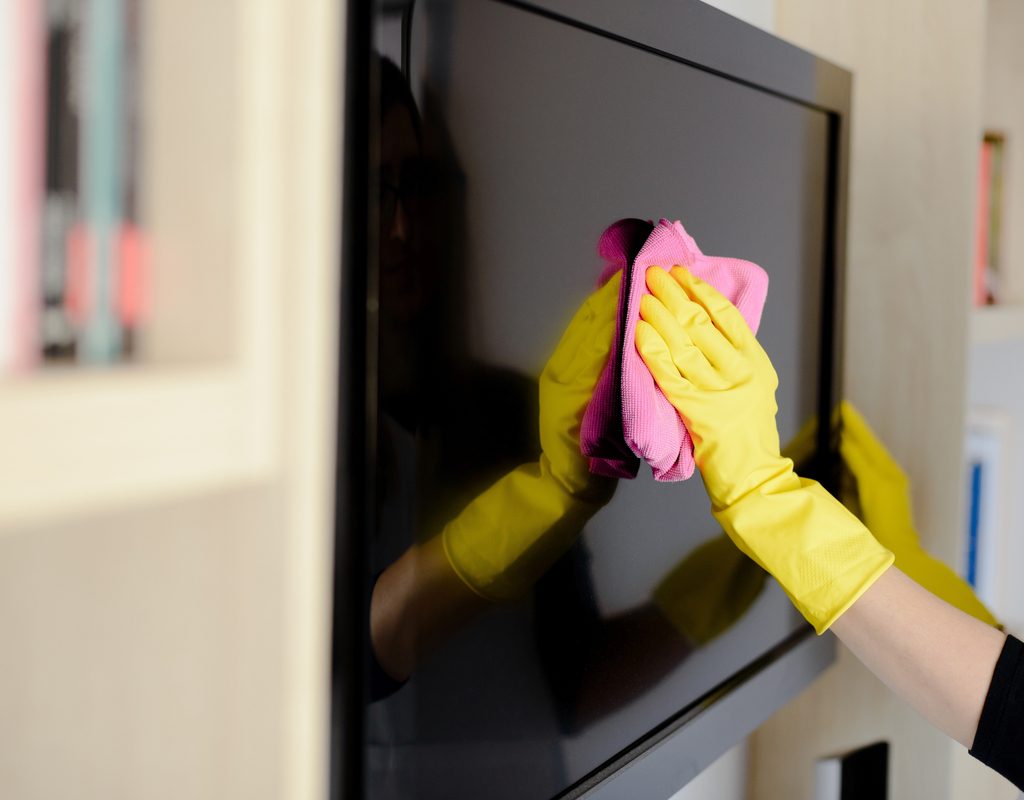 woman giving her television screan a cleaning