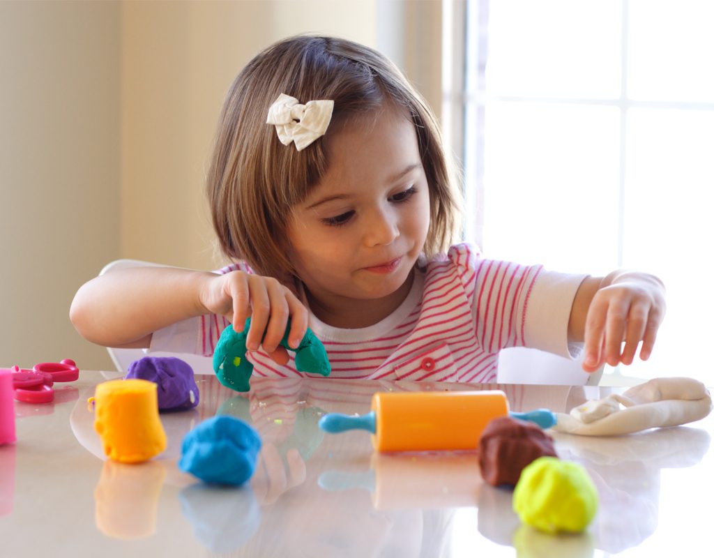 little girl having fun playing with homemade playdough