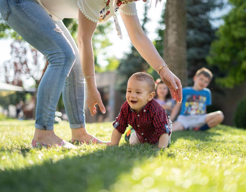 mom encouraging baby to crawl