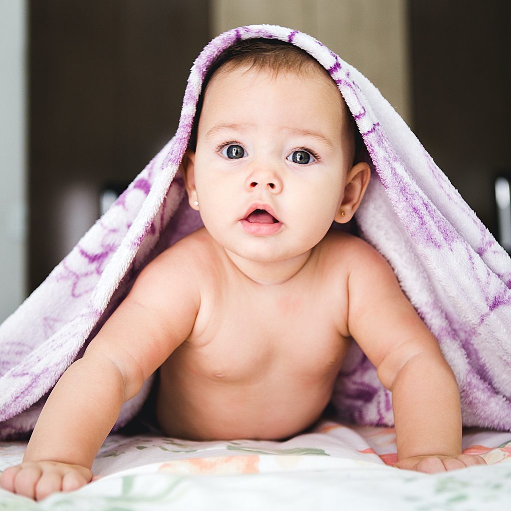 baby crawling under blanket