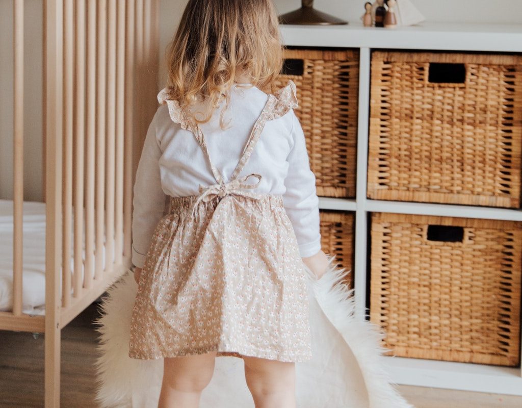 little girl standing in front of shelves