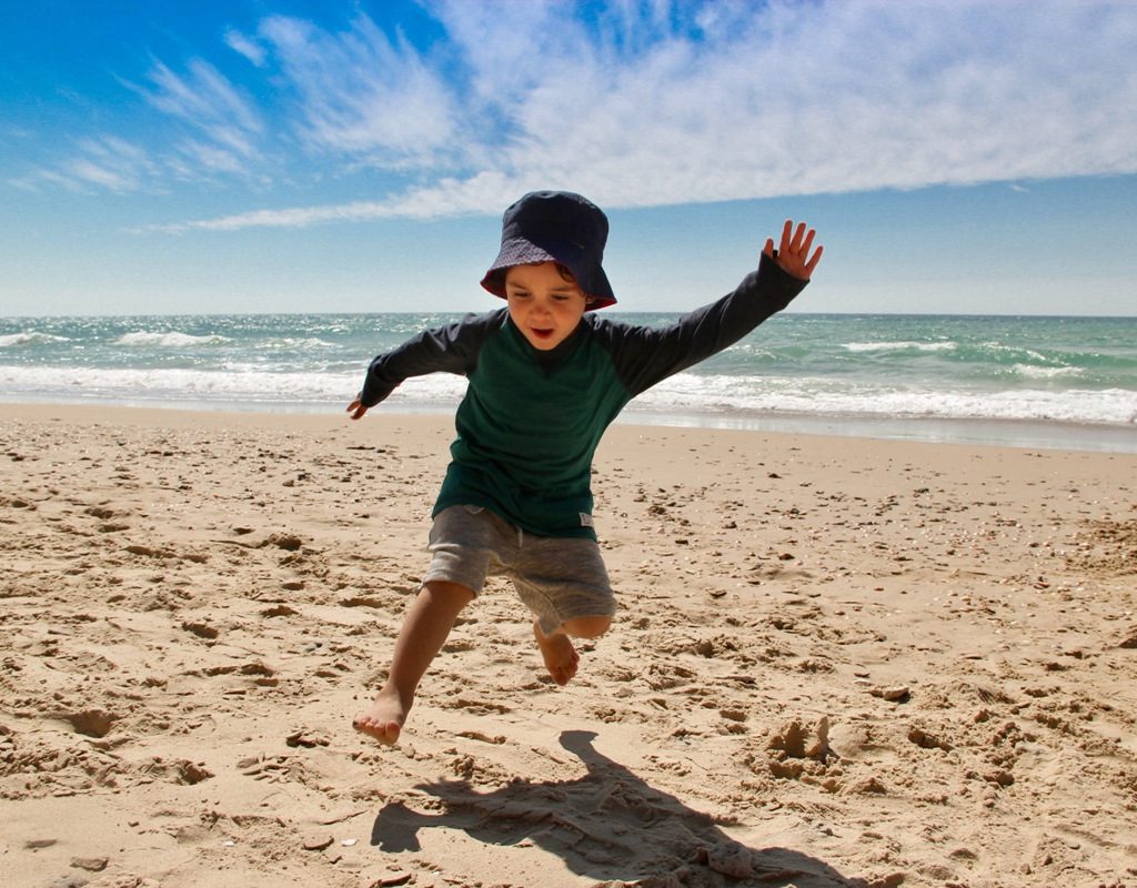 boy doing animal walk on beach
