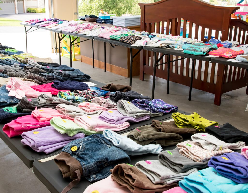 clothing for sale neatly set up on tables at garage sale