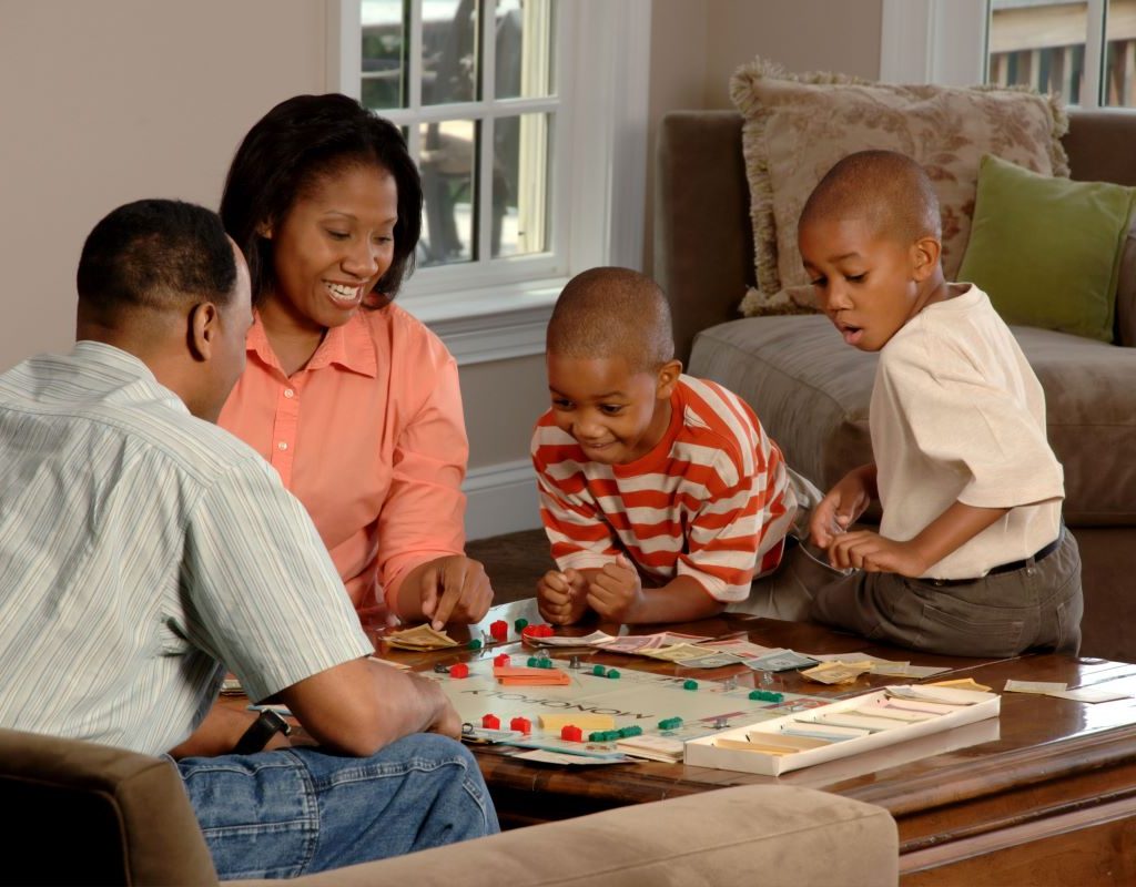 Parents with children playing a board game