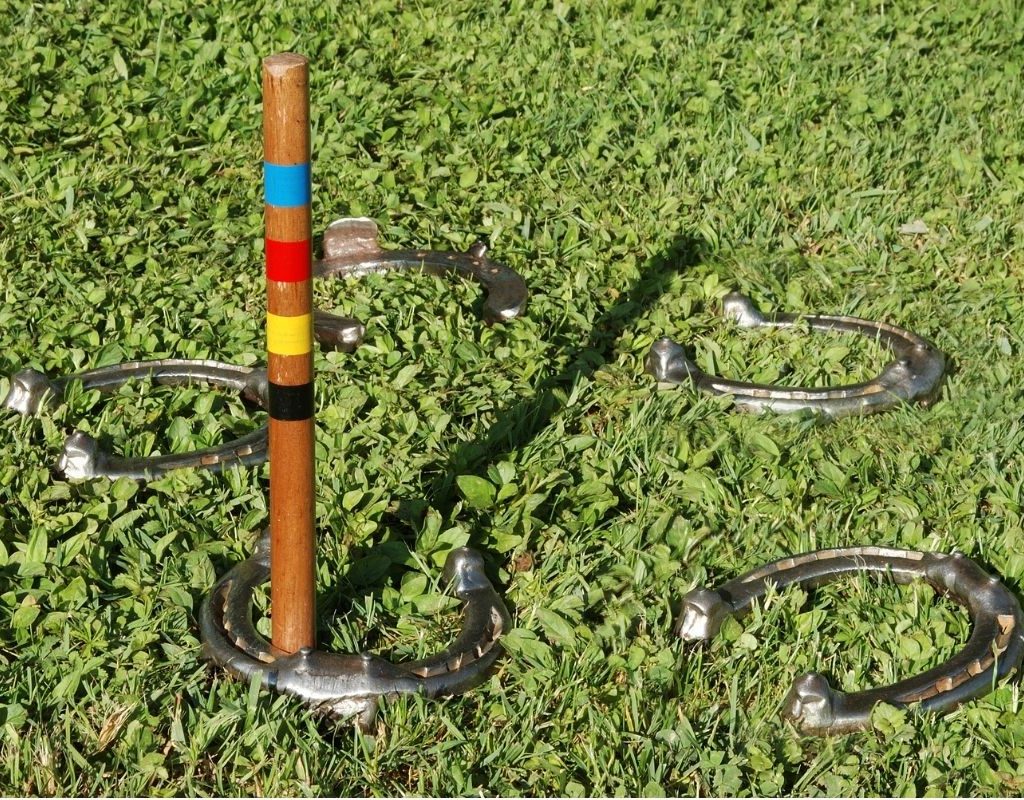 A game of horseshoes set up outside in the grass.