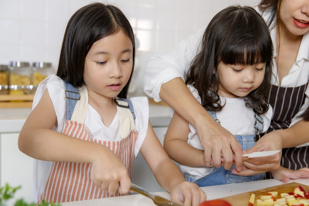Two girls helping mom with an apple recipe