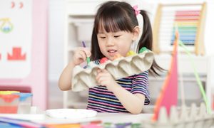 Girl painting egg carton