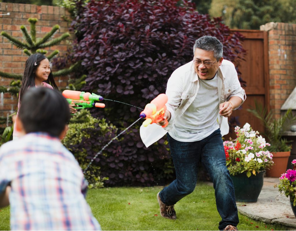 A family having a water gun fight.