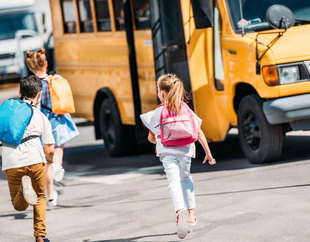 Kids running to a school bus.