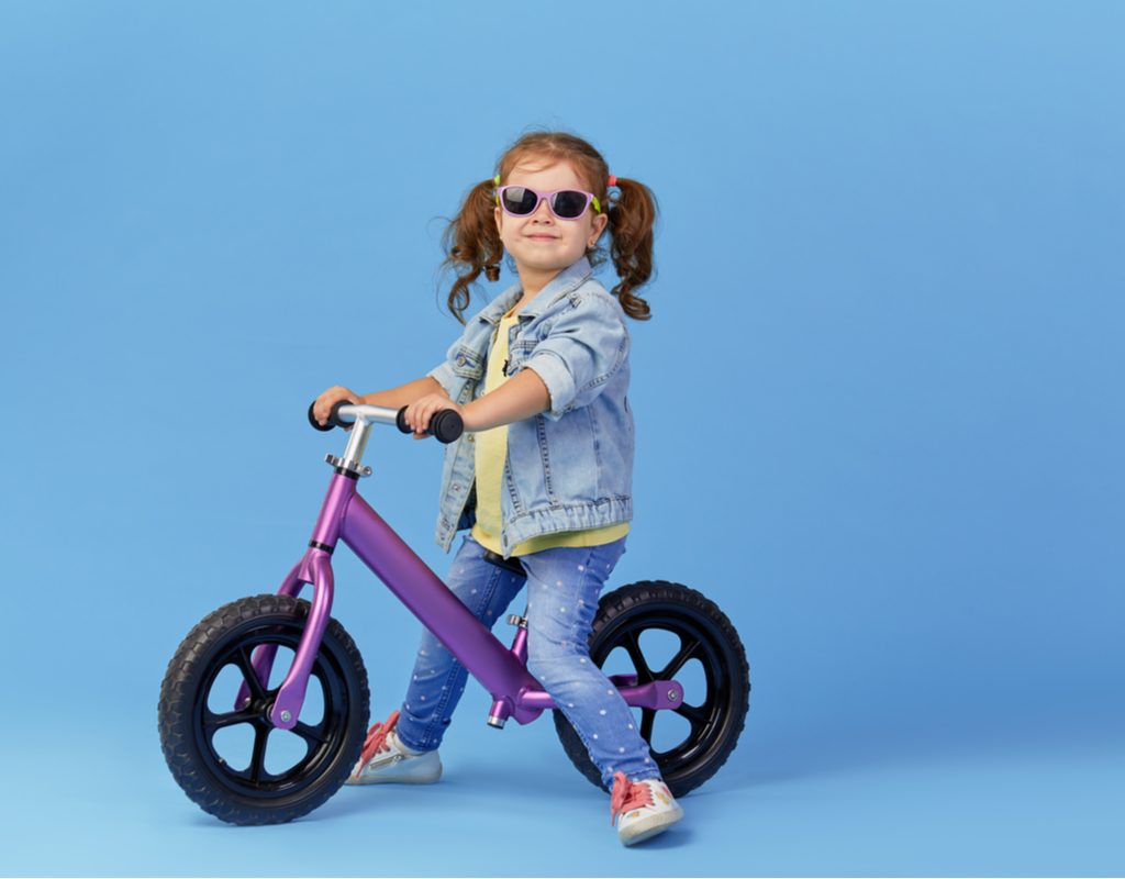 A little girl on a balance bike.