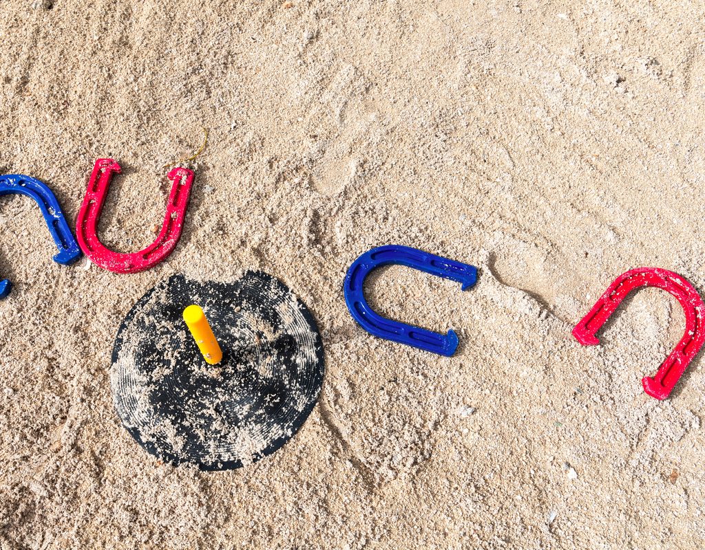 A game of horseshoes set up in the sand.