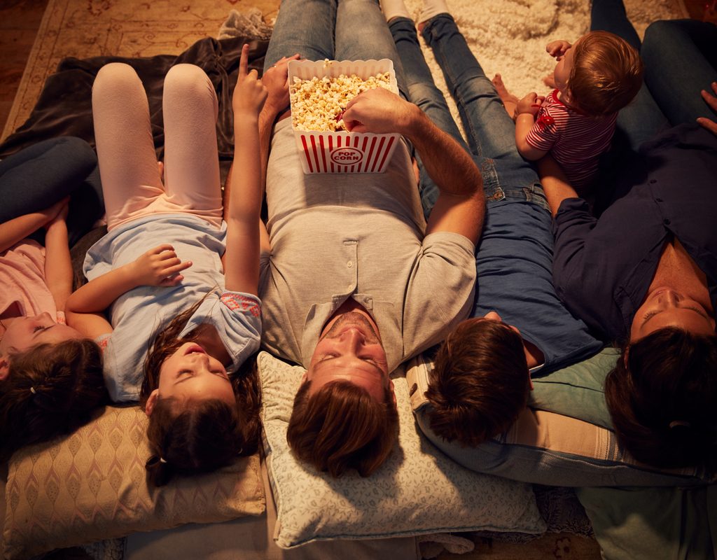 A family laying down watching a movie.