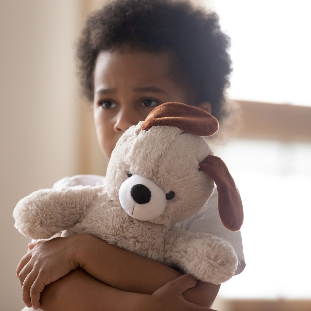 Sad toddler holder a stuffed bear