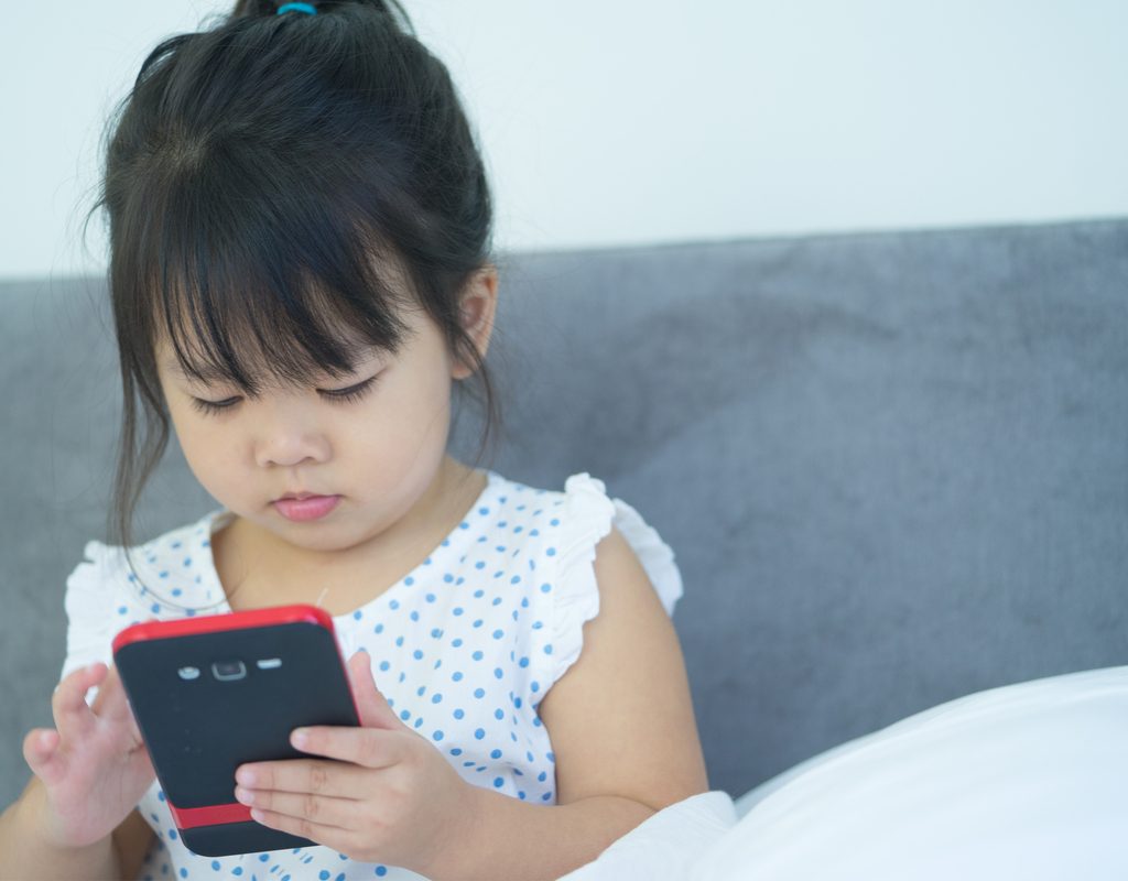 Toddler girl using educational app on smartphone