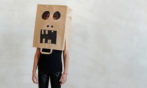 child wearing a Halloween mask made from a paper bag