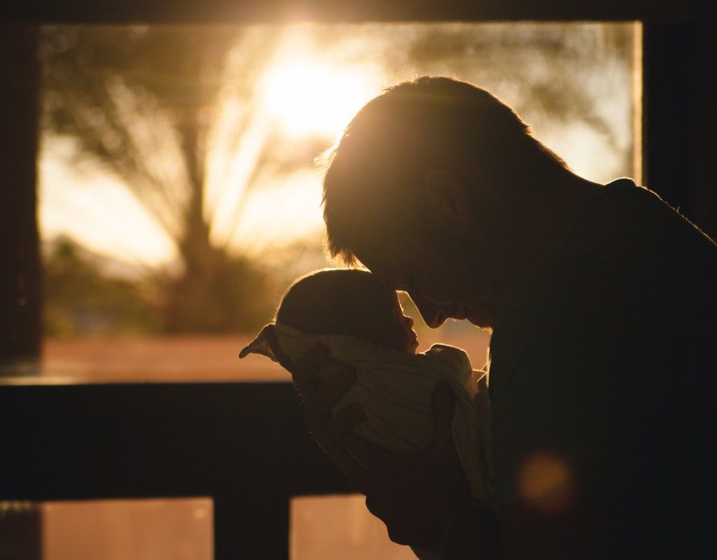 silhouette of dad holding baby