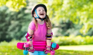 happy girl learning to ride a skateboard