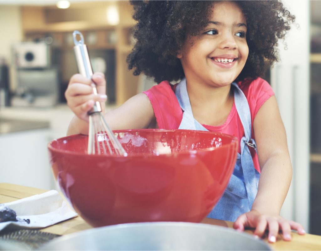 Young girl having fun cooking in the kitchen