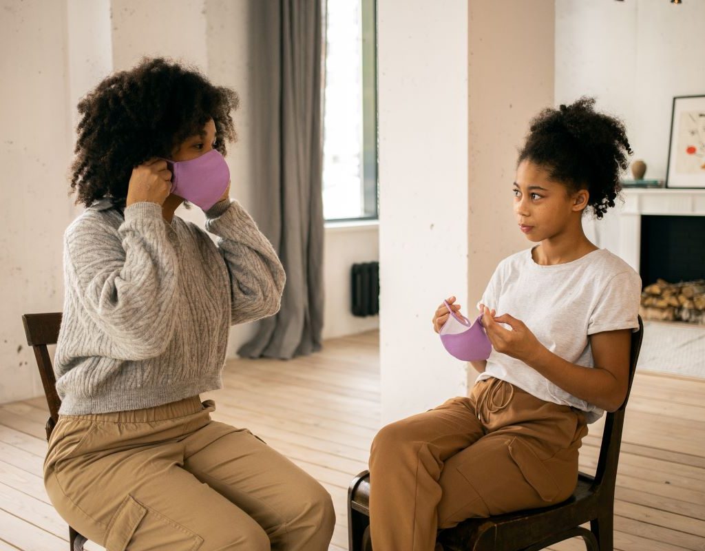 mother and teen daughter trying on masks