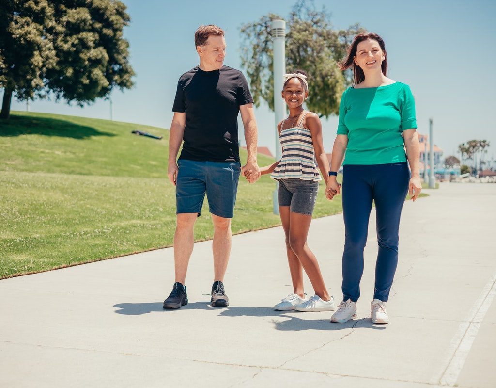 A family taking a walk on a sunny day.