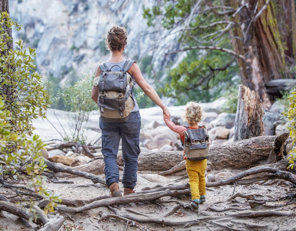 A mother and child walking in the park.