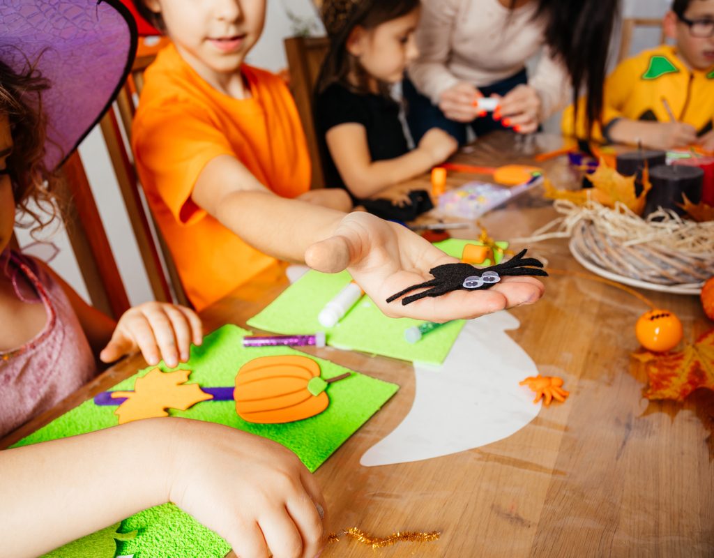 A group of children doing a Halloween craft.